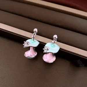 Detailed close-up view of whimsical enamel apple core earrings with sparkling zircon accents