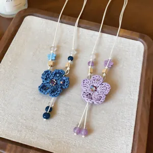 Macro view of handmade bohemian crochet flower necklaces with wood beads and crystals