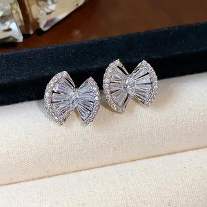 Close-up of 18k gold plated zircon bow stud earrings featuring an intricate geometric design