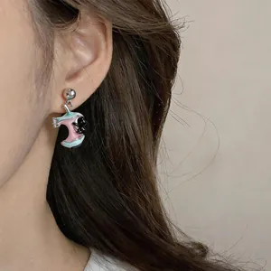 Close-up detail of a cute apple-shaped drop earring with black cat enamel design