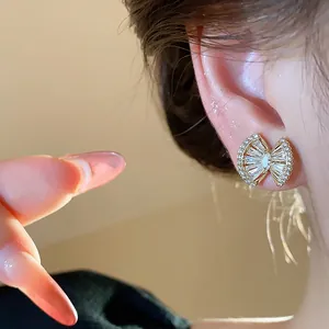 Detailed macro view of an 18k gold plated zircon geometric stud earring worn on ear