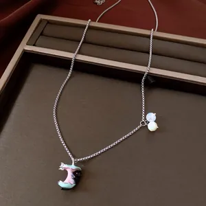 Close-up of zircon cat apple necklace with detailed enamel finish and silver-tone chain.