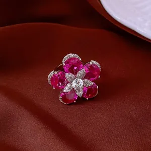 Close-up detail of an elegant flower ring with pink zircon petals on deep red silk
