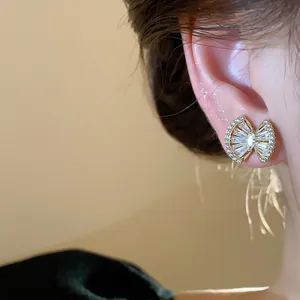 Detailed view of an 18k gold plated zircon geometric stud earring worn on the ear