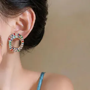 Detailed view of luxury multi-colored zircon oval hollow stud earrings on model