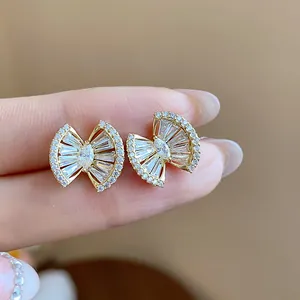 Macro detail of 18k gold plated earrings with sparkling zircon geometric stones inlay