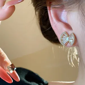 Detail view of 18k gold plated geometric earrings with sparkling cubic zirconia on ear