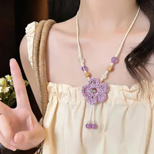Detailed view of a handmade woven purple flower necklace with beads on an Asian model.