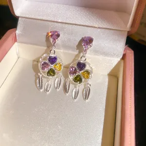 Close-up of vintage flower tassel earrings with colorful heart-shaped zircons