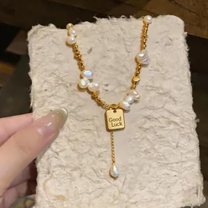 Handmade baroque pearl necklace featuring a gold Good Luck pendant and teardrop pearl