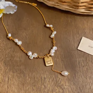 Luxury gold-tone chain necklace with natural pearls and engraved 'good luck' pendant tag