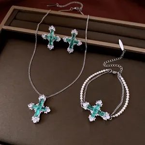 Elegant cross jewelry set with green crystals and pearls including necklace and earrings