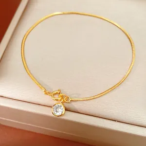 Detailansicht eines 18k vergoldeten Schlangenketten-Armbands mit rundem Zirkon-Anhänger.