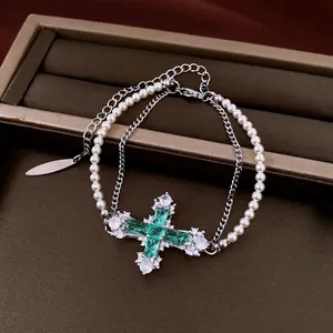 Elegant double-layer pearl bracelet featuring an emerald green zircon cross pendant for women