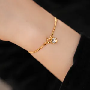 Detailaufnahme eines eleganten 18k vergoldeten Schlangenarmbands mit Zirkonia-Anhänger