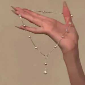Detailed view of an elegant French style pearl necklace with a dainty flower pendant