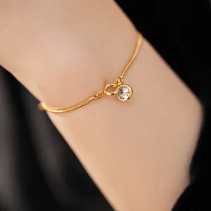 Detailaufnahme eines 18k vergoldeten Schlangenkettenarmbands mit rundem Zirkonia