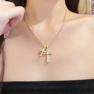 Elegant gold double cross pendant necklace with sparkling cubic zirconia for women.