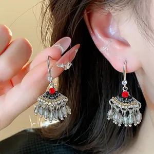 Détail de boucles d'oreilles vintage en forme d'éventail avec strass et glands