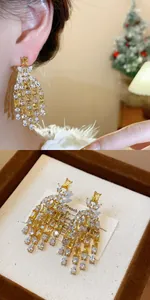 Dettaglio di squisiti orecchini a nappa in zircone giallo e bianco in una scatola regalo