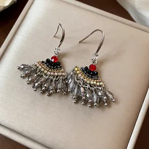 Gros plan sur des boucles d'oreilles vintage en forme d'éventail avec strass