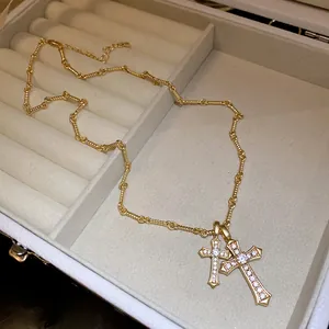 Detailed macro view of double gold cross pendants with zircons in a jewelry box.