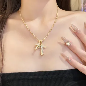 Macro view of gold cross pendant necklace with sparkling zircons on model