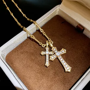 Macro detail of gold double cross pendant necklace with sparkling zirconia stones