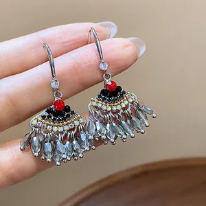 Détail rapproché de boucles d'oreilles ethniques vintage en forme d'éventail à glands