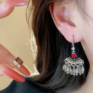 Gros plan de boucles d'oreilles ethniques avec strass colorés et glands en perles