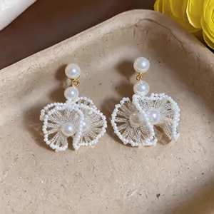 Vue détaillée de boucles d'oreilles rétro avec dentelle perlée et perles élégantes