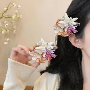 Detail of beach vacation hair clip with shell flower, starfish and pearl decor