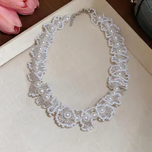 Gros plan d'un collier de perles vintage français avec détails en dentelle de cristal