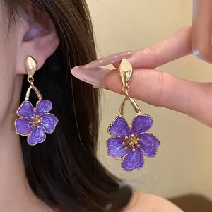 Elegant purple enamel flower drop earrings with vintage golden metallic finish for women.