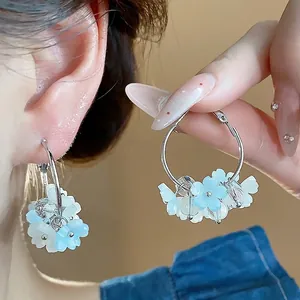 Orecchini a cerchio con fiori in resina e ago in argento per un look fresco ed elegante.