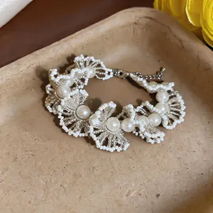 Gros plan détaillé d'un bracelet de perles vintage français aux motifs de dentelle complexes.
