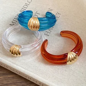 Set aus drei eleganten, transparenten Manschettenarmbändern aus strukturiertem Harz.