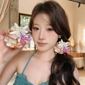 Close-up of starfish and shell flower hair clip worn by a model for beach holidays.