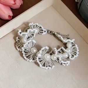 Détail d'un bracelet en perles rétro français avec des perles de cristal argentées et dentelle.
