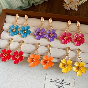 Collection of colorful vintage enamel flower dangle earrings in a display box.