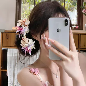 Close-up detail of beach style hair clip featuring fabric flowers, shells and pearls