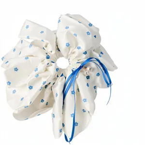 Elegant white floral scrunchie with blue ribbon bow and pearl charm hair accessory
