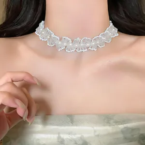 Gros plan d'un collier ras du cou en dentelle blanche vintage avec perles élégantes