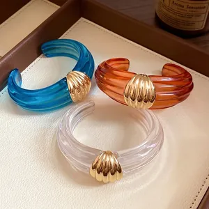 Elegante transparente Harz-Manschettenarmbänder mit goldenem Muschel-Strukturdesign