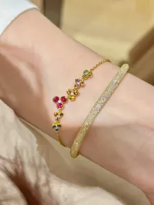 Gros plan de bracelets en or élégants avec motifs floraux colorés et pierres brillantes