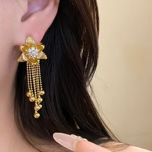 Detailed view of 18k gold plated flower earrings with zircon and ball chain tassels