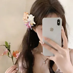 Close-up of a beach style seashell and fabric flower hair clip on wavy brown hair