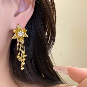 Detailed macro view of 18k gold plated flower tassel earrings featuring zircon inlay