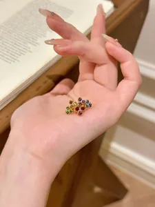 Détail d'un bracelet de fleurs colorées avec des pierres précieuses sur une monture dorée.