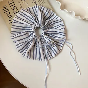Detail of elegant blue and white striped scrunchie with silver bow and long ribbons
